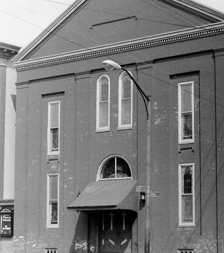 Front façade detail of the church showing the entry and upper windows.